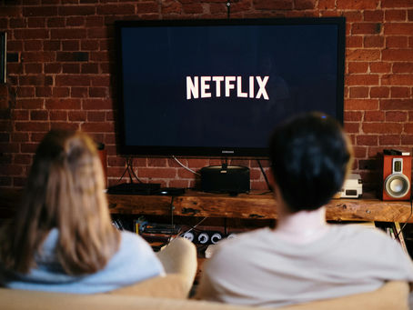 Casal assistindo Netflix em casa, exemplo de gasto variável com streaming abordado em conteúdos de educação financeira do blog Carteira de Renda.