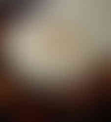 A cream-colored pumpkin painted with a black silhouette of a witch in profile, framed by an ornate oval border with a spider hanging from a web above her hat. The pumpkin is topped with a large orange bow with black polka dots, creating a stylish Halloween decoration.