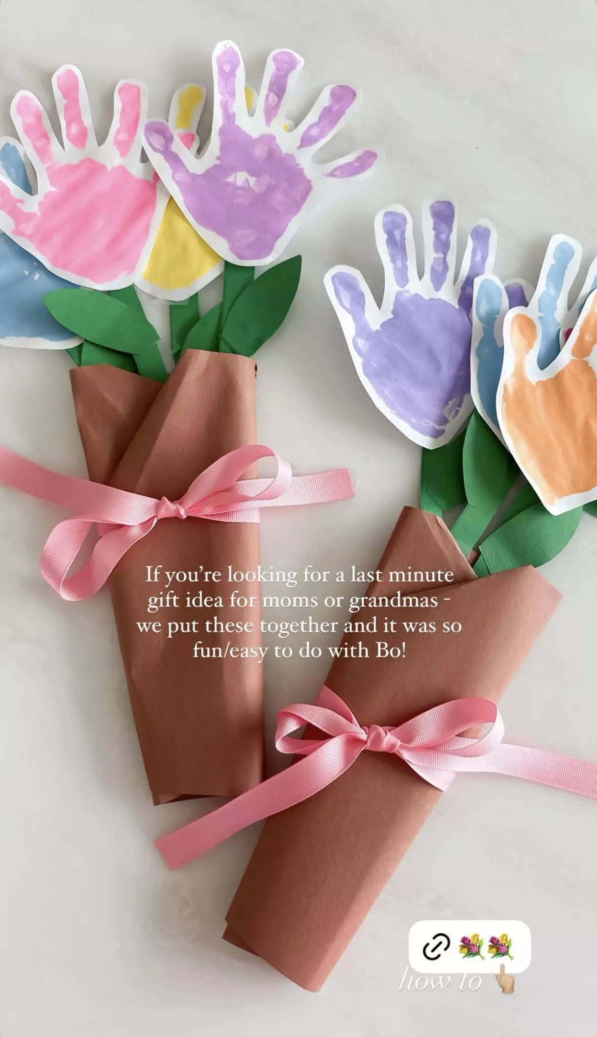 Paper handprint cutouts arranged as flowers and wrapped in brown paper with a pink ribbon, styled as a bouquet gift.