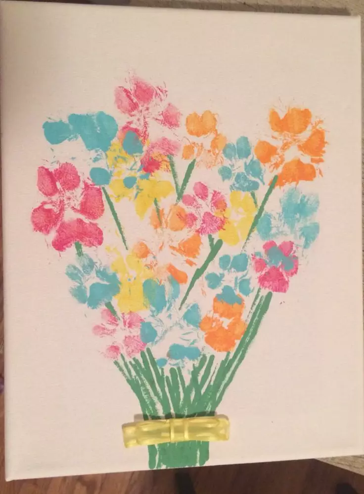 Colorful pawprint flowers in pink, yellow, orange, and teal arranged in a bouquet on a white canvas, with green stems and a ribbon detail at the base, a pet friendly idea.