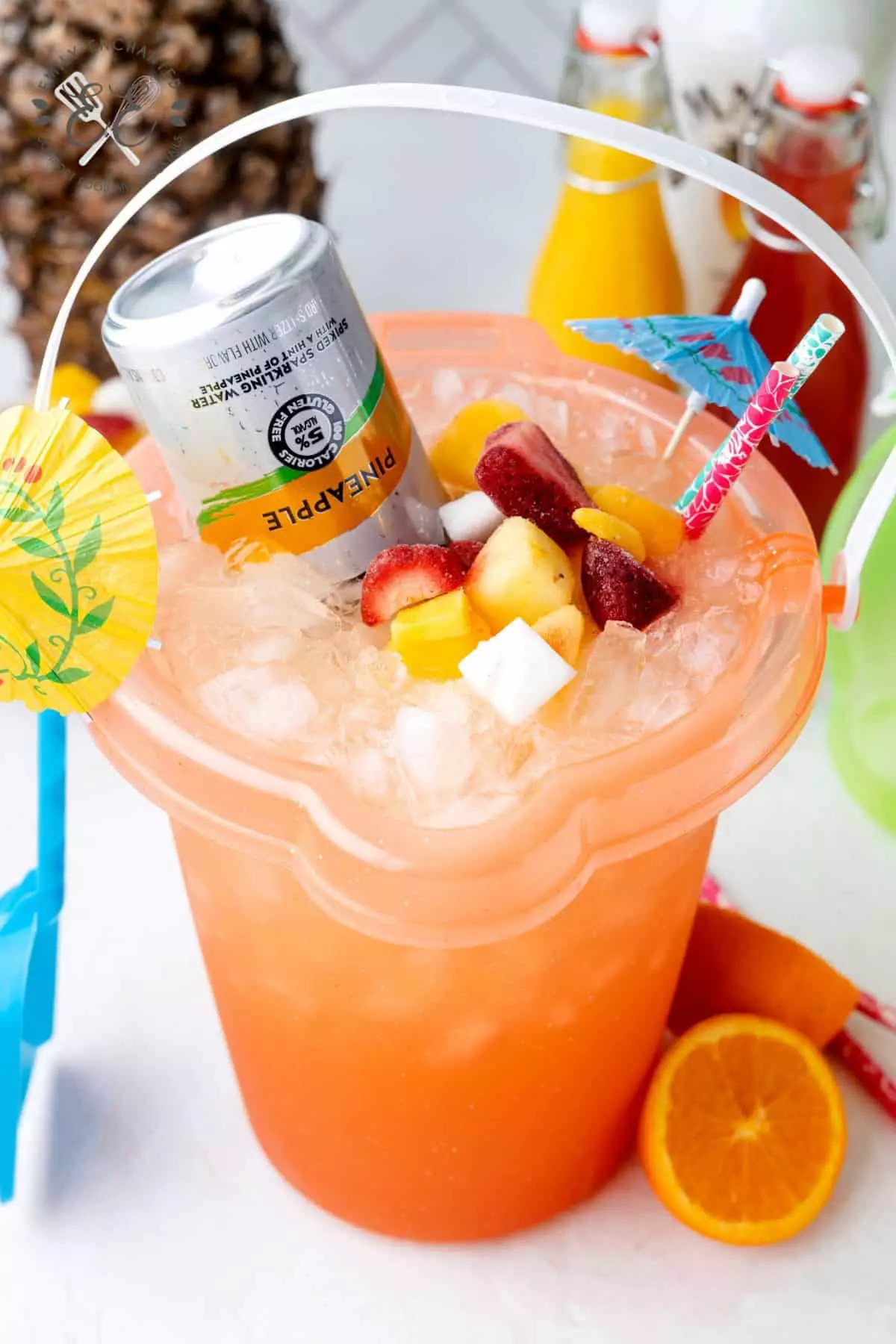 Mother’s Day poolside cocktail mocktail bucket with fruit, drinks, and tropical decor for apartment resident event ideas.