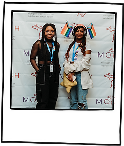 Two smiling youth with pride flags