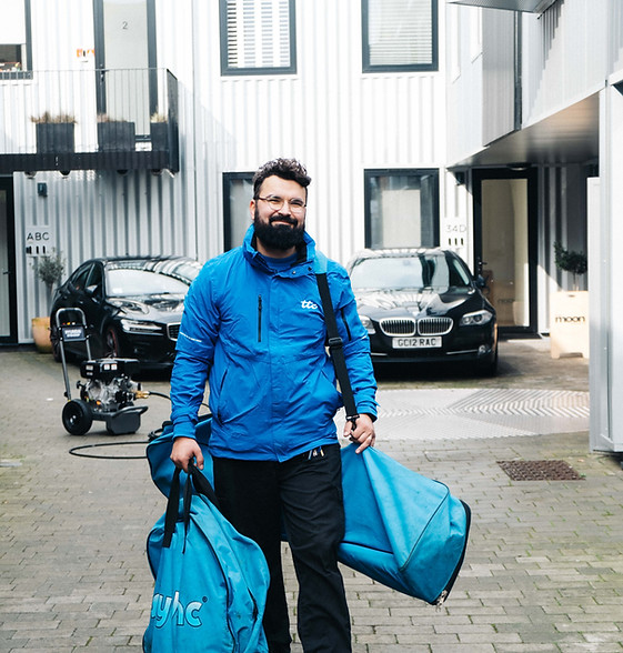 staff member carrying gutter cleaning equipment