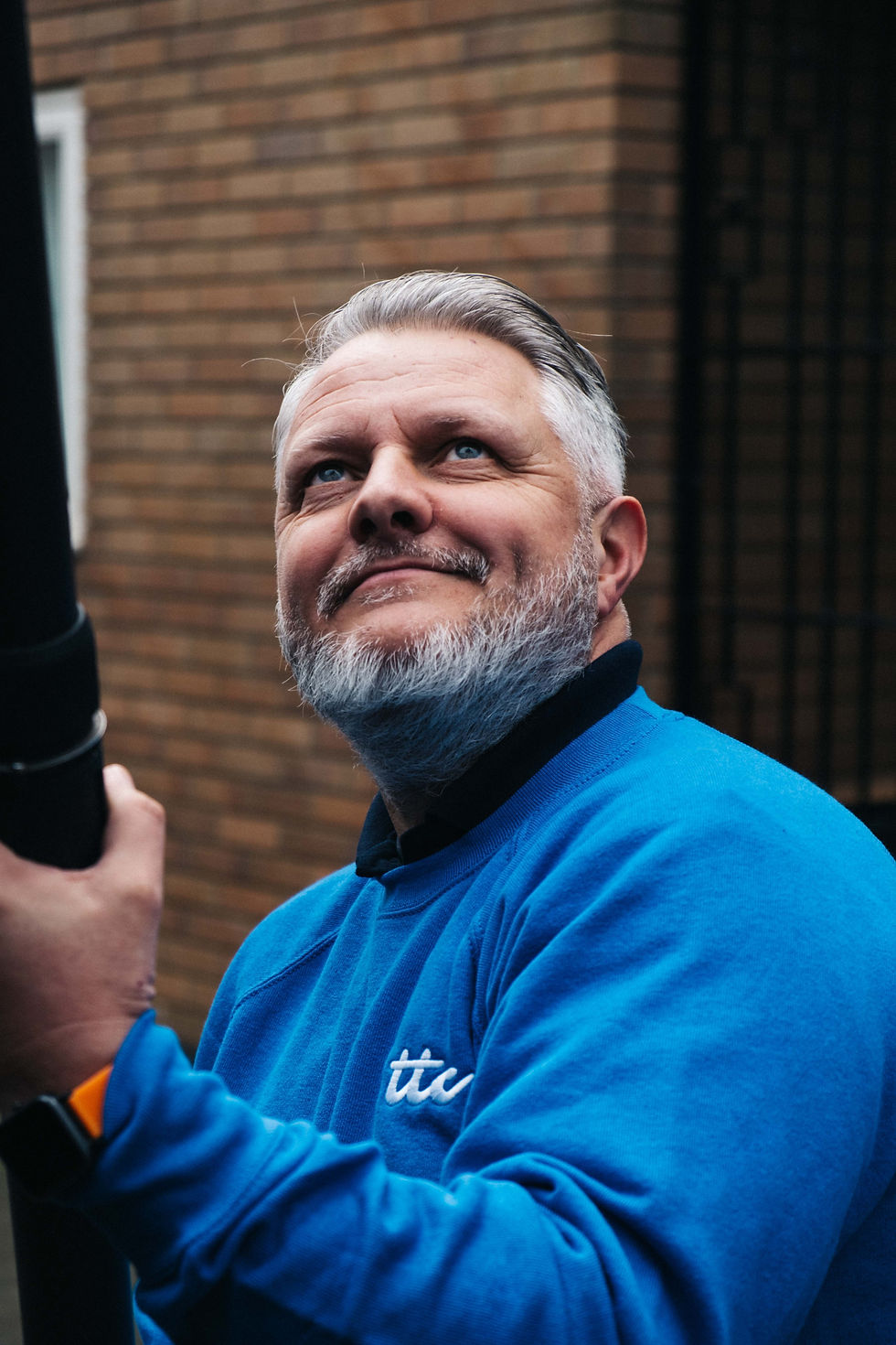 Uniformed member of staff using the gutter clearing equipment.