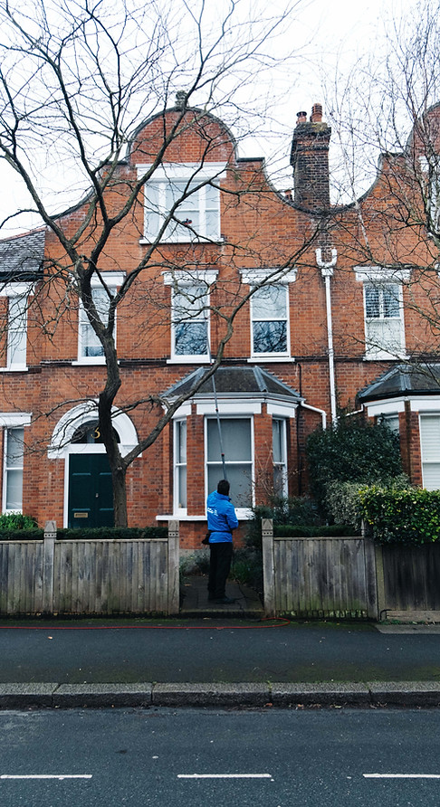 staff member cleaning the front windows of a residential property