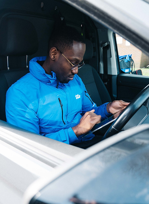 staff member checking his iPad while sitting in the car in front of the steering wheel