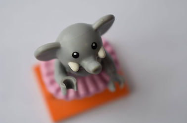 A Birds Eye view of a lego elephant in a tutu standing on an orange platform