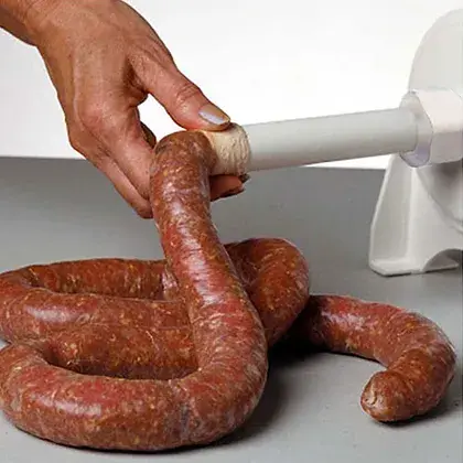Thumbnail: Homemade sausage links being filled with spiced ground meat using the Dakotah Sausage Stuffer.