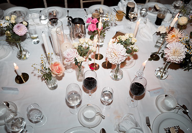 Elegant table setting with flowers, candles, and glasses; formal event.