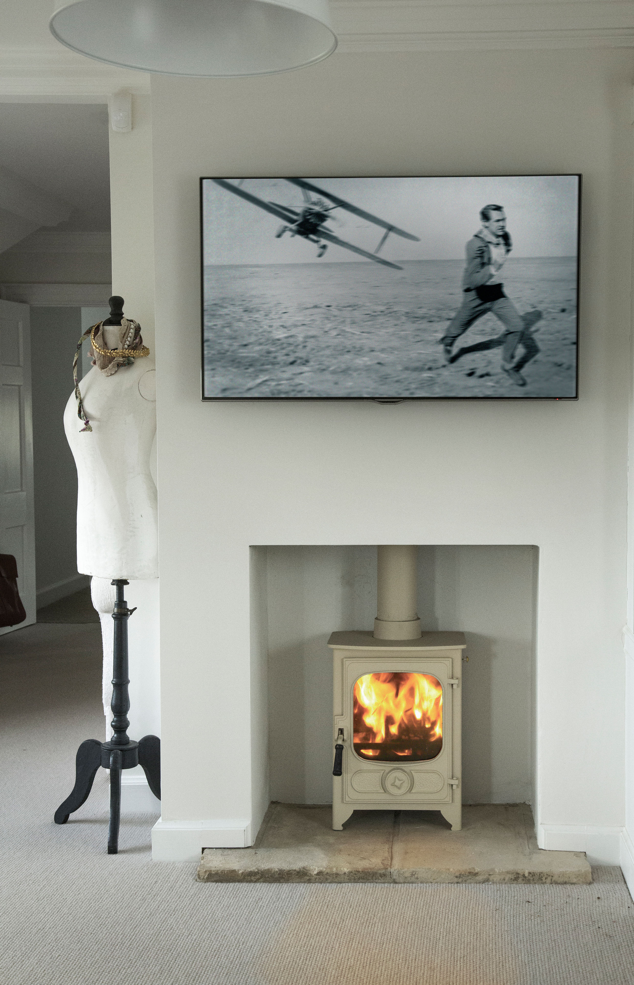 Lit Charnwood Country 4 woodburning stove in Almond within a modern fireplace
