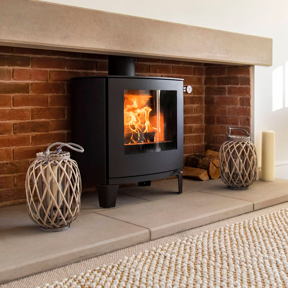 Thumbnail: ARais Q-Tee 2 C wood burning stove in a brick fireplace with a timber mantle over and fireplace decorations