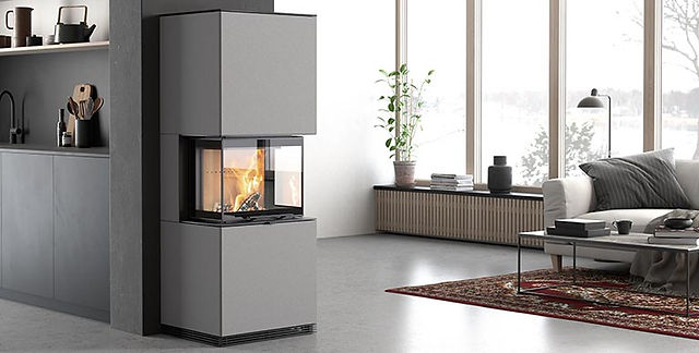 Minimalist Scandi Living Space with large window in back ground with wood paneling under, persian rug positioned under occassional table by sofa, Contura i61 is postioned oposit the seating area and is clad in grey stone making the 3 sided fireplace blend in to the surrounding room colours