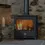 Thumbnail: A lit Chilli Penguin Woody wood stove in a stone fireplace