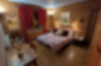 Miniature : Chambre double de la Suite Alpages aux murs en lambris de bois, décorée avec une affiche vintage du fromage Beaufort