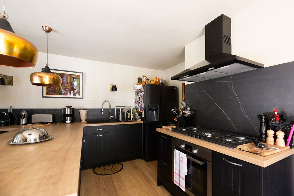Cuisine moderne avec meubles noirs et plans bois clair
