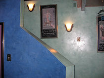 A picture of a stairway wall done in smooth coat interior plaster with soft blue and green hues.