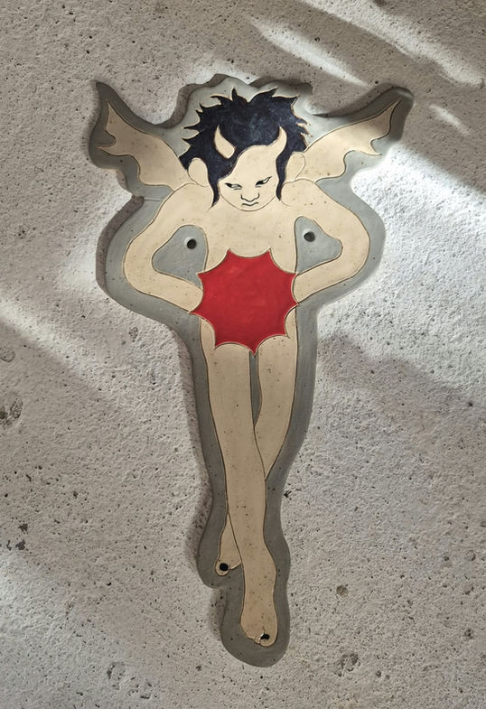 Large ceramic wallhanging in grey, beige and red, depicting an demonic angel holding a bursting star
