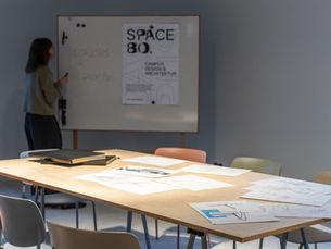Team arbeitet gemeinsam an Workshop-Aufgaben in kreativer Atmosphäre bei SPACE BO und entwickelt neue Ideen durch aktive Zusammenarbeit.