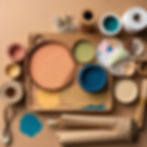 a wooden table covered with paint, papers, crafts with natural colours and tones.jpg