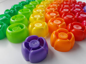 Rainbow baby food pouch caps in a sensory bin (baby food squeeze tops, lids)