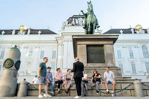 tom bachinger guiding a group of tourists in front of a statue in Vienna, Austria