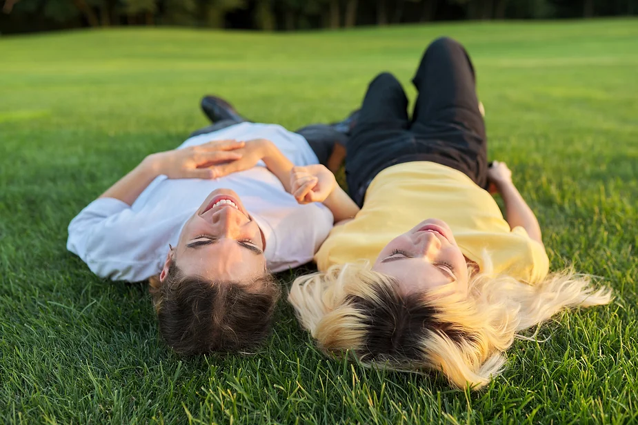 Two people lying in the grass showing how happy you are with orgasm after menopause