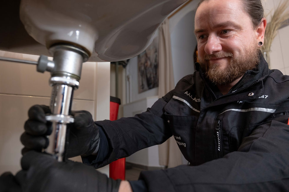 Klempner schraubt Rohr zusammen