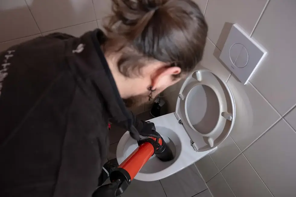 Rohrreiniger beseitigt eine hartnäckige Verstopfung in einer Toilette mit professionellem Werkzeug