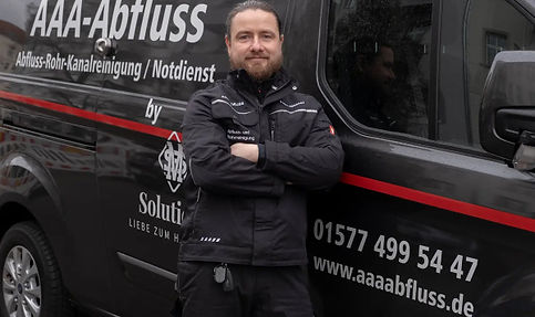 Rohrreiniger von AAA-Abfluss vor seinem Firmenwagen in Berlin – Experten für Rohrreinigung und Abflussnotdienst