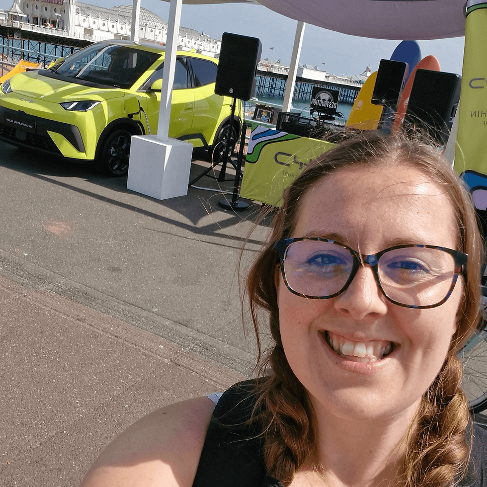 Smiling woman takes a selfie with a bright green car in the background, set on a sunny pier. Festive and vibrant colors create a lively atmosphere.