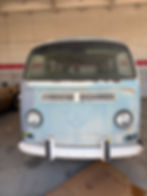 Vintage light blue Volkswagen Type 2 bus parked in a garage.