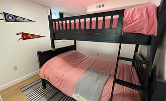 Bunk room with a black twin-over-full bunk bed and pink bedding