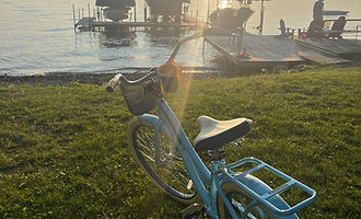 Teal cruiser bike parked on the grass at the lakefront at golden hour