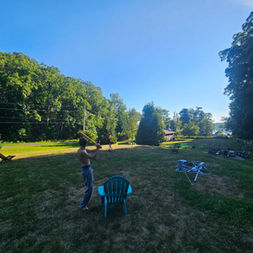 Lawn games and Adirondack chairs on a sunny summer lawn