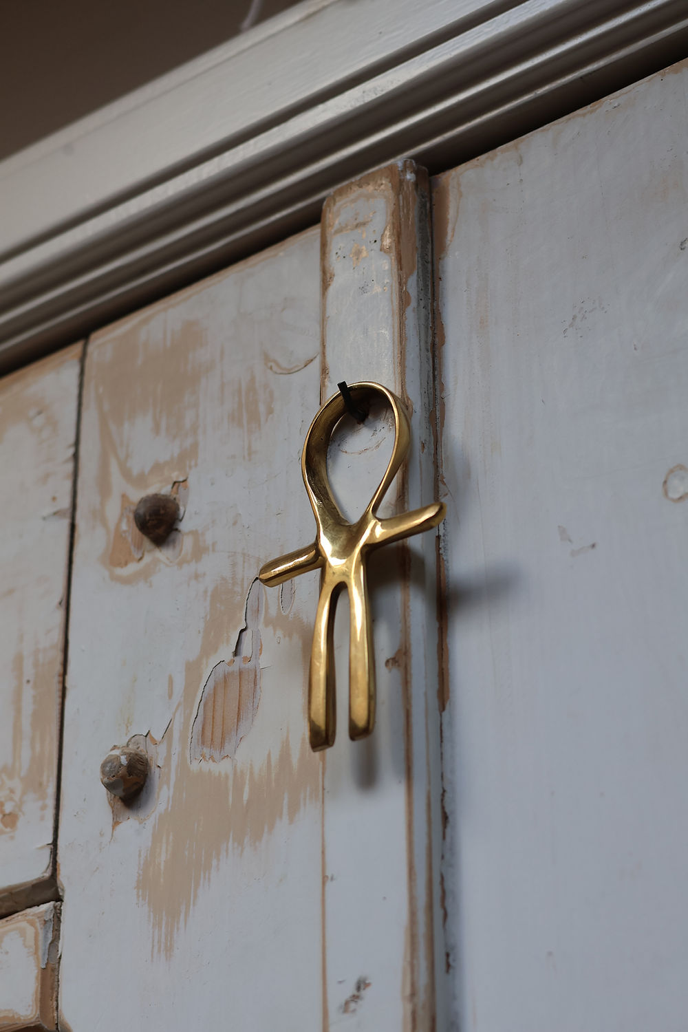 ankh hanging on a white old door