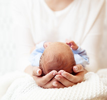 Baby Head in Mother Hands. Mum holding Newborn Boy lying on White Blanket. Infant Health C
