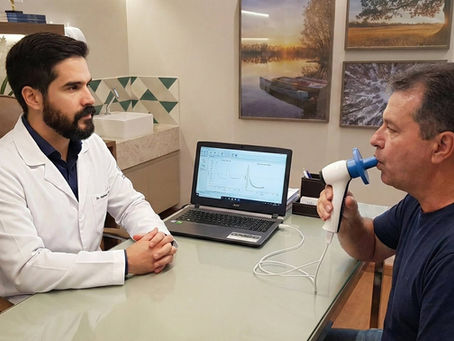 Um médico faz o exame de espirometria em seu paciente