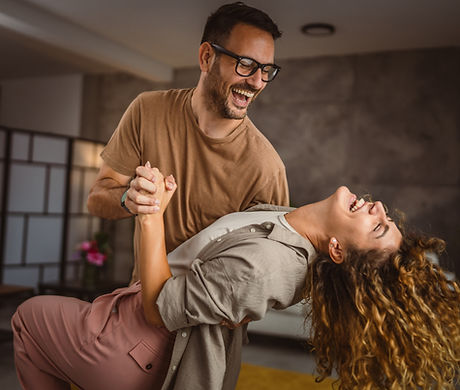 Happy in love couple man woman husband and wife dance at home have fun.jpg