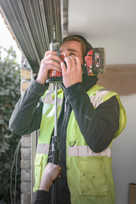 Window installer fixing head of frame up into timber.