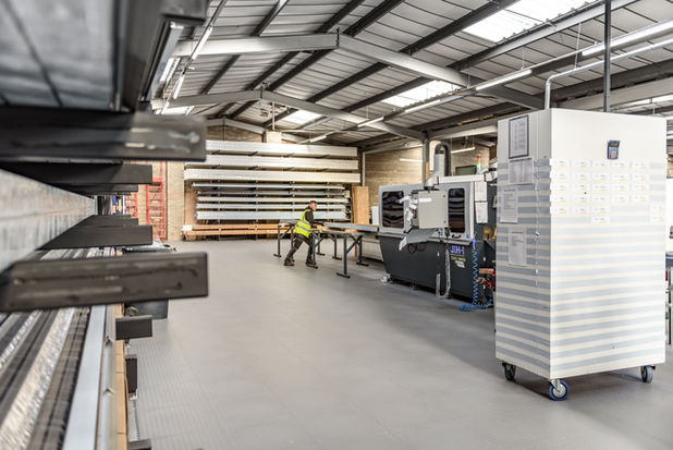 Technician feeding aluminium profile into CNC machine. 