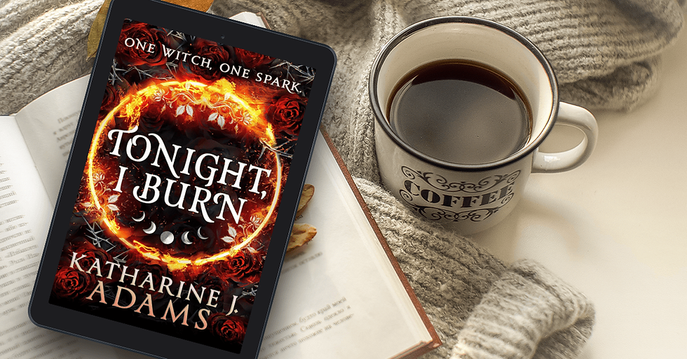 The cover of Katherine J Adams' novel 'Tonight, I Burn' placed over an open book with a cup of coffee