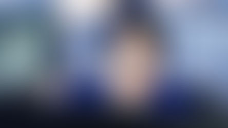 A lady wearing glasses looking at an unseen screen