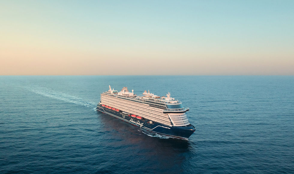 Large cruise ship Mein Schiff Flow sailing on calm blue sea under a pastel sky, leaving a wake.