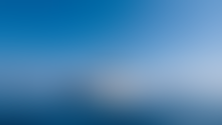 Sleek white luxury yacht cruising on calm blue sea under a clear sky, with its reflection shimmering on the water.