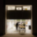 A yellow autonomous marine vehicle is being wheeled out of a workshop sliding door at night