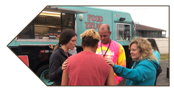 No Boundaries International volunteers talking to a man near a food truck.