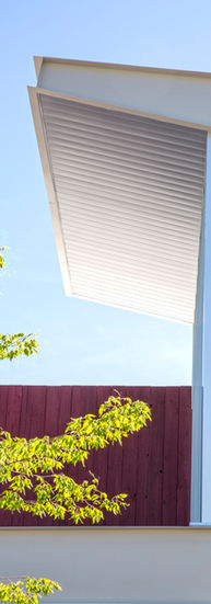 Close up of the roof. A white roof overhang and a glass window are attached to the red roof.