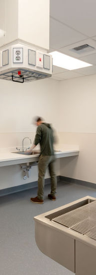 A person washes their hands at a scrub station in the operating room.