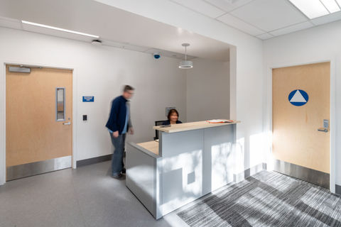 People talk by a reception desk. 
