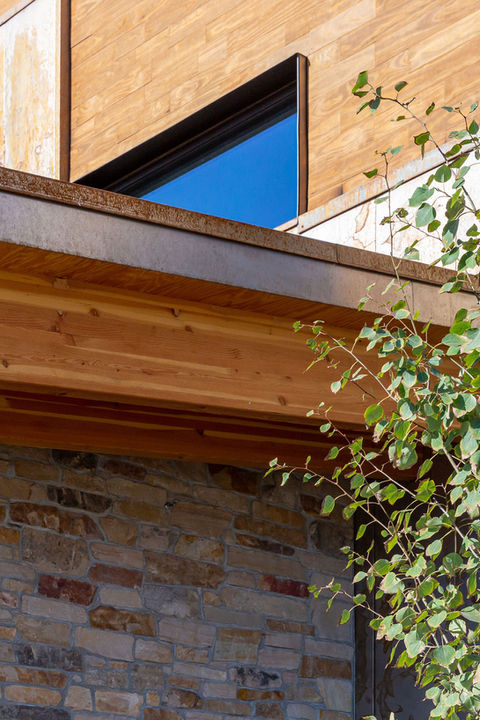 A close up of the materials on the building. The walls have multi-colored brick, and the roof is wood.